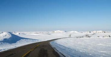 Pictured: A road with a snowy surrounding in Bismarck North Dakota.