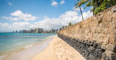 Pictured: A cement wall and beach in Hilo Hawaii.